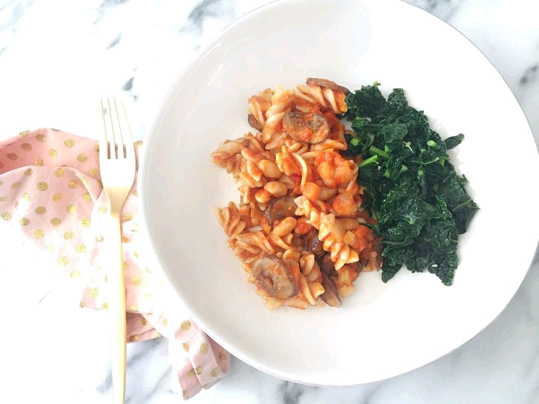 Brown rice pasta with a white bean and mushroom bolognese, and garlic kale